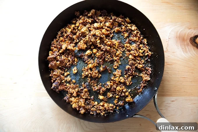 Irresistible finished tofu crumbles in a skillet, showcasing their perfect crispness and rich glaze.