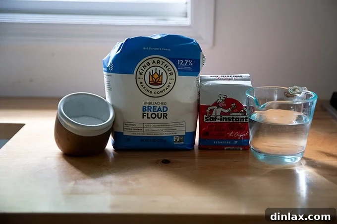 Essential ingredients for baguettes—flour, salt, yeast, and water—arranged on a clean countertop.