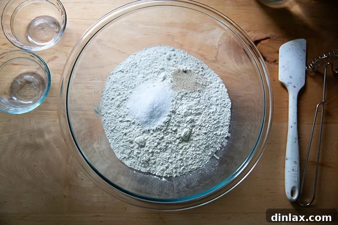 Dry ingredients for baguettes, including flour, salt, and yeast, in a large mixing bowl.