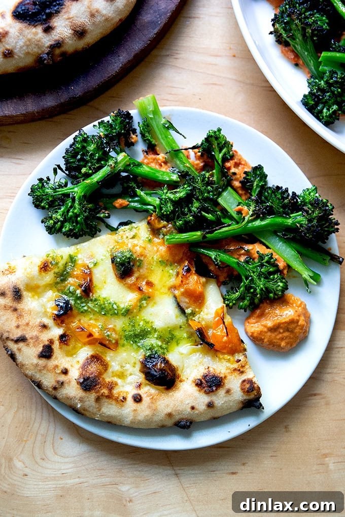Zahmetsiz Romesco Sosu: Biberleri Soymaya Son! 16 A slice of pizza aside charred broccolini on top of romesco sauce.
