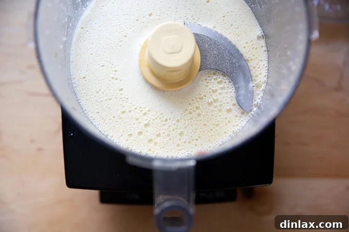 Perfect Caesar Dressing Your Way 7 The food processor bowl now contains a smooth, blended mixture of lemon juice, white balsamic vinegar, egg yolks, anchovies, and garlic.