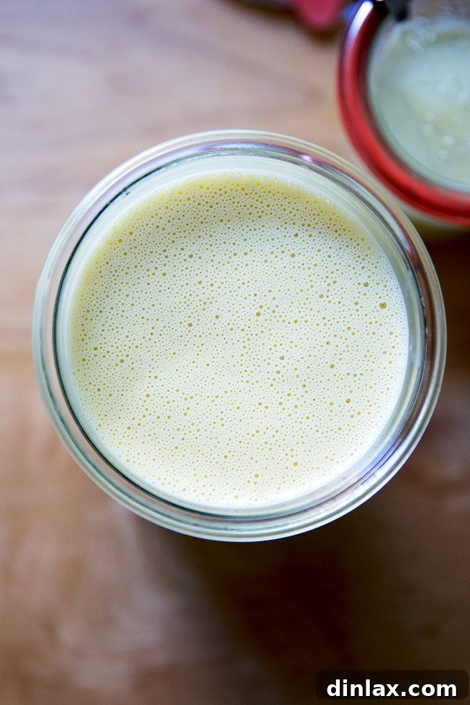 Perfect Caesar Dressing Your Way 10 A single clear glass jar filled with the freshly made Caesar dressing, showcasing its creamy texture.