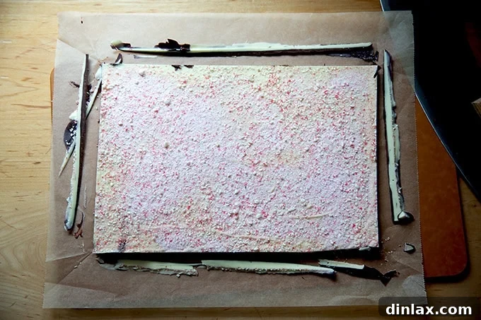 Simple 4-Ingredient Peppermint Bark 17 Edges trimmed from the peppermint bark on a cutting board.