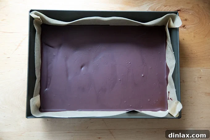 Simple 4-Ingredient Peppermint Bark 10 A layer of chilled set dark chocolate in a 10x14-inch pan.