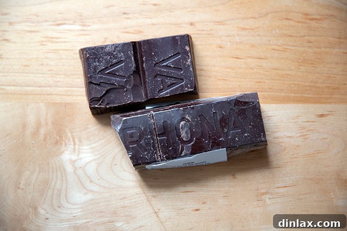 A bar of Valrhona 70% cacao bittersweet chocolate on a countertop, ready to be chopped.