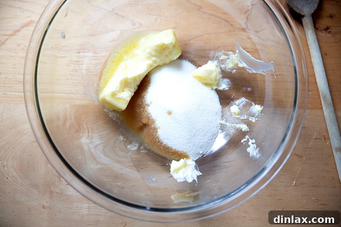 A bowl with butter, sugar, and vanilla extract unmixed, awaiting the creaming process.