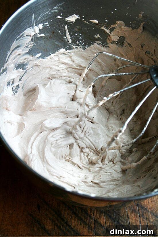 Applying whipped cream frosting to angel food cake