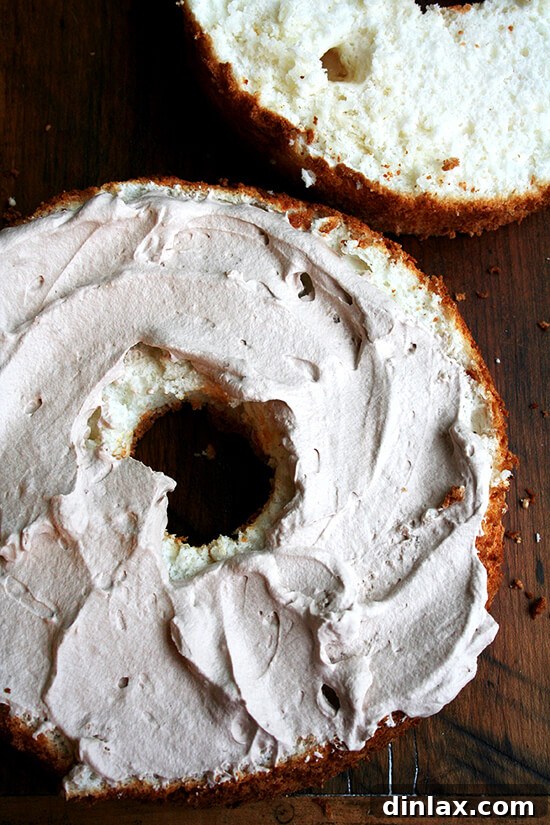 Frosted and halved angel food cake, showcasing layers