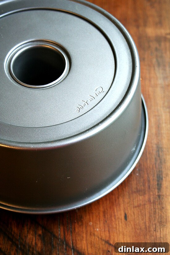 Angel food cake cooling upside down on a rack