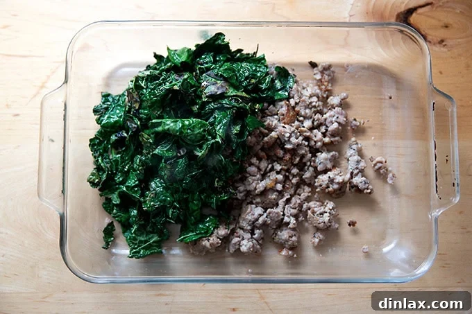 Effortless Baked Pasta: Make It, Share It, Freeze It 12 A 9x13-inch baking pan filled with a mixture of sautéed kale and browned sausage.