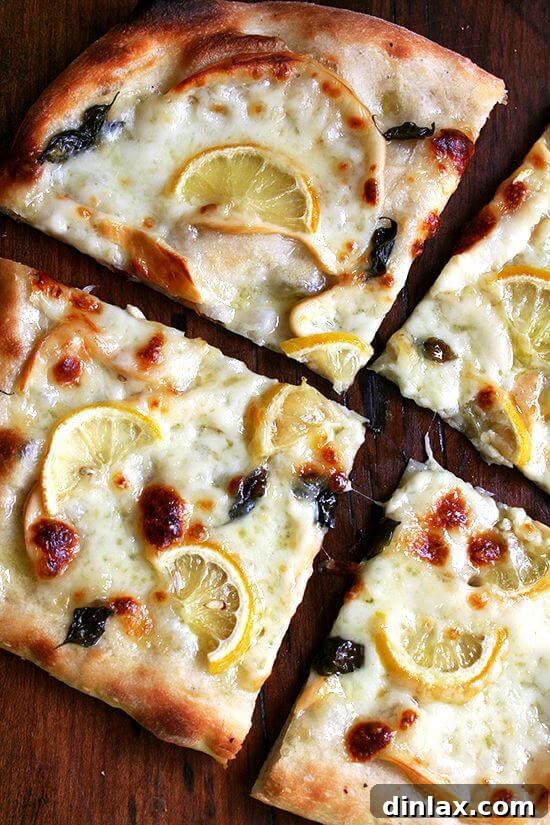 Zesty Lemon, Smoked Mozzarella & Fresh Basil Pizza 2 An overhead shot of a sliced lemon pizza.