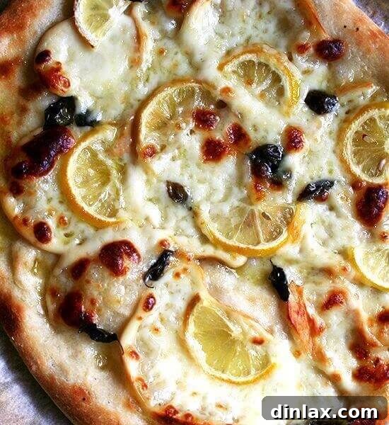 Overhead shot of a sliced Lemon & Smoked Mozzarella Pizza.