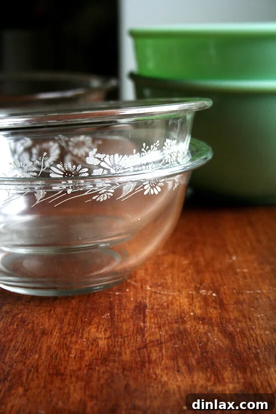 Two pyrex bowls stacked on wooden surface