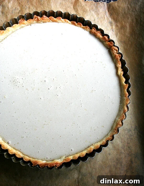 The meticulously prepared tart, filled with its creamy maple custard, poised for baking. Unbaked maple cream tart in its pan, ready to go into the oven.