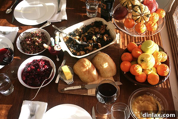 A meticulously set dining table, adorned with dishes and cutlery, awaiting the Thanksgiving feast.