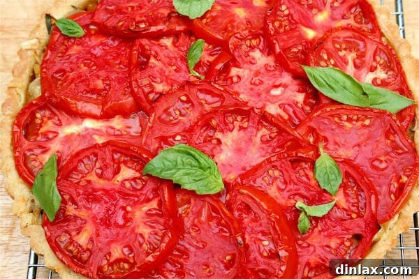 Beautiful heirloom tomato tart, golden brown and garnished with fresh basil