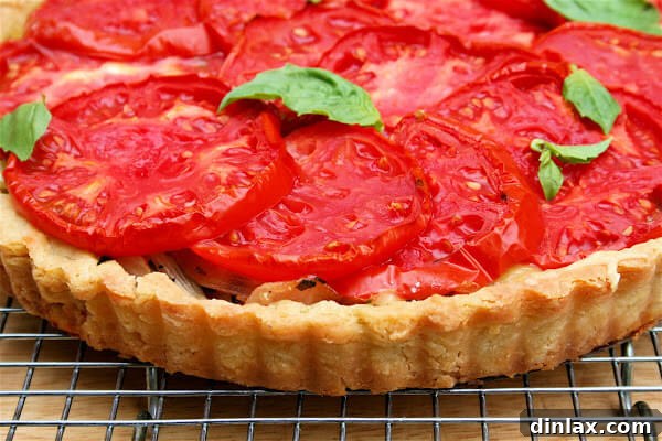 Close-up of a slice of heirloom tomato tart, showing layers of filling and flaky crust