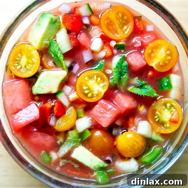 A pristine glass bowl showcasing the beautiful magenta hue of watermelon gazpacho, ready for serving.