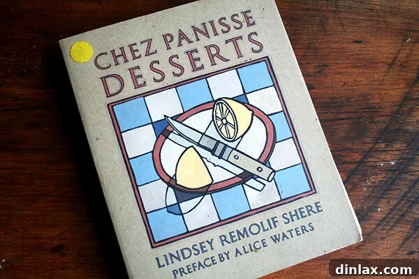 Classic Chez Panisse Almond Torte 2 The classic Chez Panisse Desserts cookbook resting on a rustic wooden table.