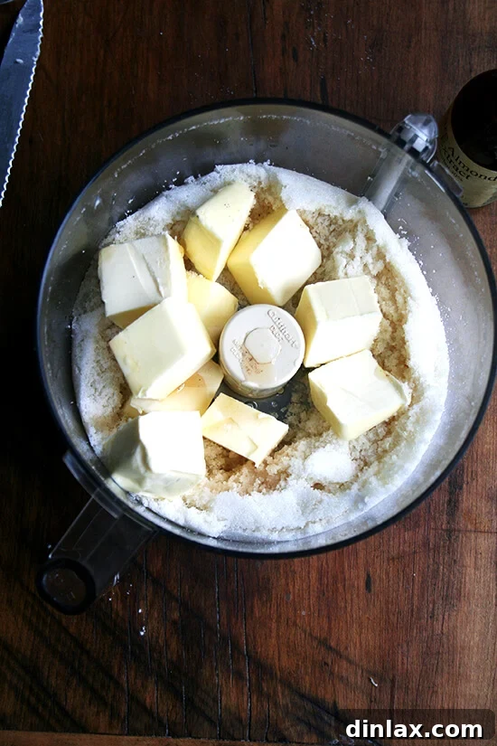 Classic Chez Panisse Almond Torte 7 Softened butter and vanilla extract being added to the almond paste and sugar mixture in the food processor.