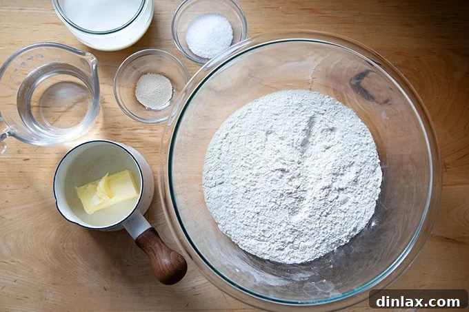 Pillowy Soft No Knead Sandwich Loaf 3 All the essential ingredients for making delicious sandwich bread laid out on a kitchen counter.