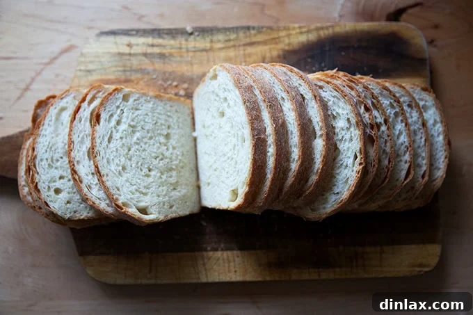 Pillowy Soft No Knead Sandwich Loaf 21 A close-up view of a perfectly sliced loaf of soft sandwich bread on a cutting board, ready to be enjoyed.