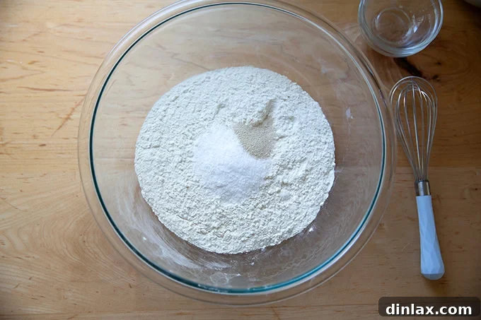 Pillowy Soft No Knead Sandwich Loaf 5 A large glass bowl containing bread flour, salt, and instant yeast, ready for whisking.