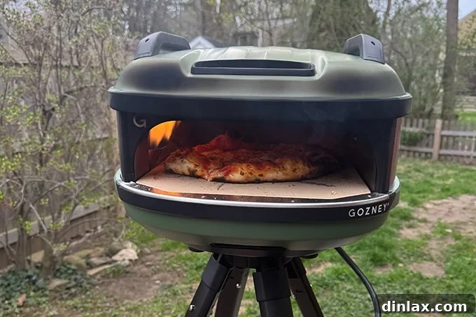 Mother's Day Gift Inspiration 18 The Gozney Tread pizza oven actively baking a pizza outdoors, showcasing its compact design.