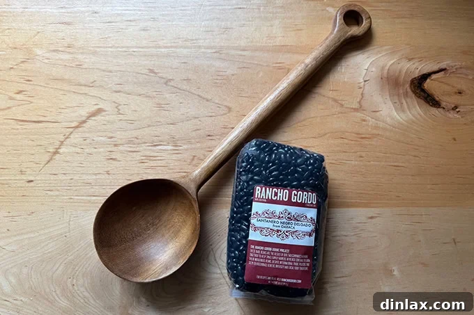 Mother's Day Gift Inspiration 7 A rustic wooden bean spoon next to a bag of high-quality, heirloom Rancho Gordo beans.