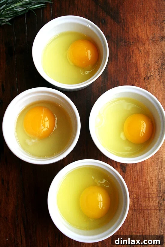 4 ramekins each holding an egg.