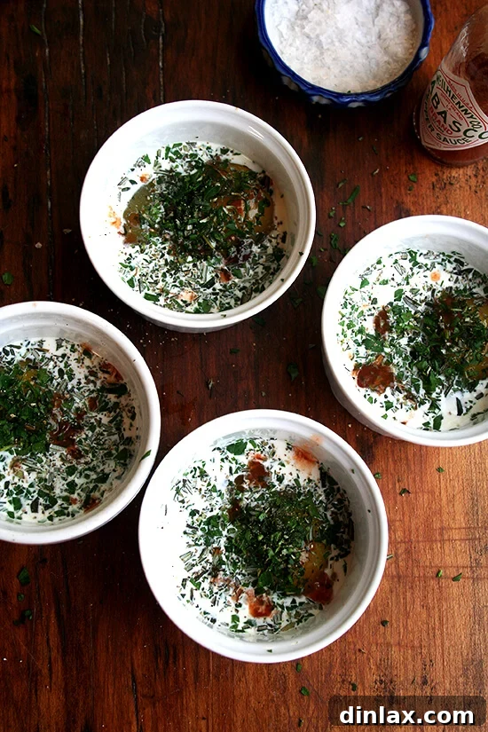4 ramekins, each holding an egg, cream, herbs and tabasco 