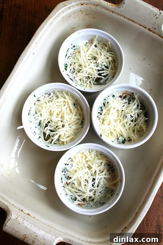 4 ramekins, filled with baked eggs, in a baking dish.