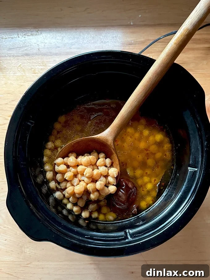 9 Awesome Father's Day Gift Ideas 13 A comforting pot of slow-cooked chickpeas, with the elegant wooden bean spoon gently resting inside, inviting a taste.