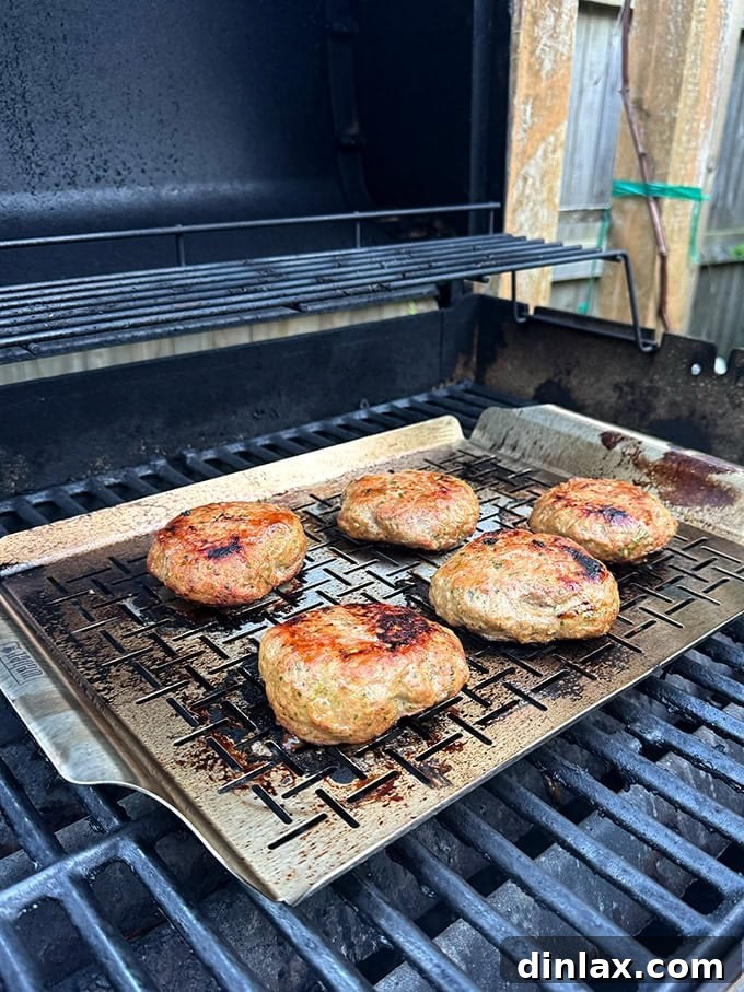 9 Awesome Father's Day Gift Ideas 4 Perfectly cooked, juicy turkey burgers sizzling on the Weber grill pan, showcasing its non-stick capabilities.