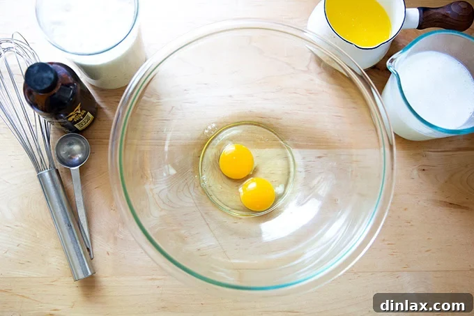 Quick Light and Fluffy Sourdough Discard Pancakes 4 Two eggs in a large bowl aside buttermilk, melted butter, vanilla, and sourdough discard.