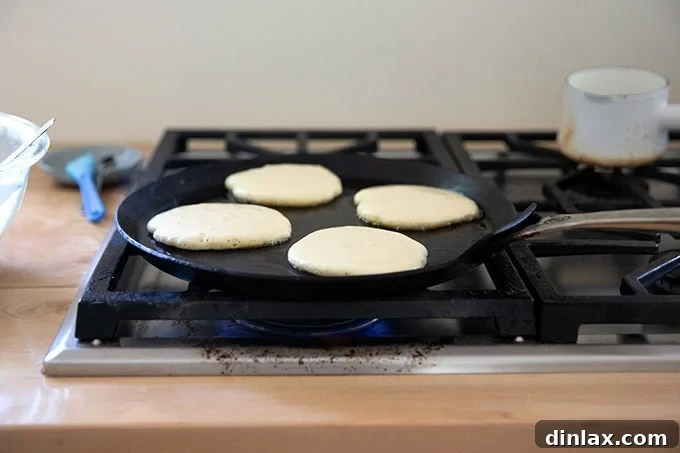 Quick Light and Fluffy Sourdough Discard Pancakes 10 Sourdough discard pancakes cooking in a skillet.
