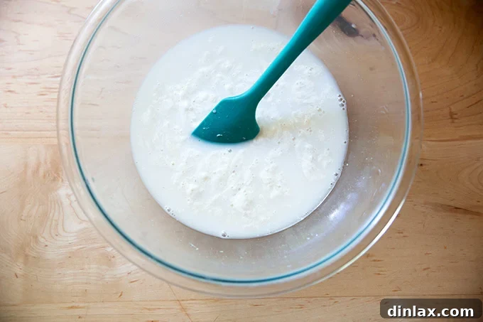 The bowl now contains a thoroughly stirred blend of water, yeast, salt, honey, and sourdough discard, forming a uniform liquid base.