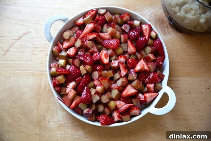 A baking dish beautifully filled with the vibrant strawberry and rhubarb mixture, awaiting its topping.