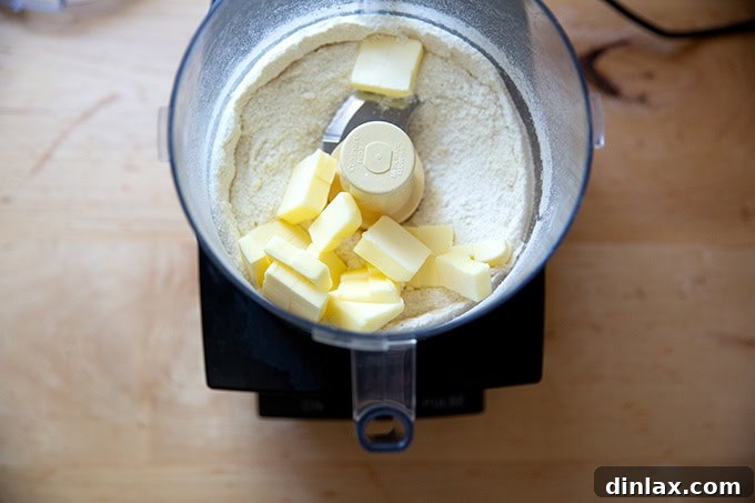 Dry ingredients for the crisp topping in a food processor, with cold butter cubes just added before final processing.