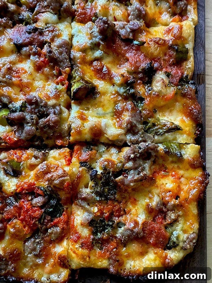 Freshly baked Grandma-style pizza on a wooden cutting board, meticulously sliced into square portions, highlighting its golden, crispy crust and rich toppings.