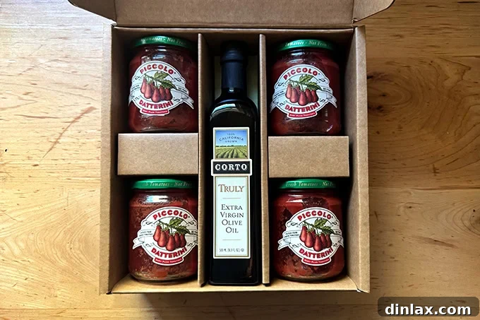 A thoughtful ensemble featuring a box of premium Piccolo Datterini tomatoes and a bottle of Corto extra-virgin olive oil, highlighting essential ingredients for gourmet cooking.