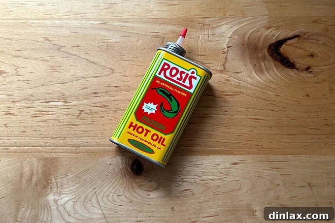 A vibrant tin of Rosi's hot chili oil, its colorful packaging suggesting a bold and flavorful condiment perfect for pizza enthusiasts.