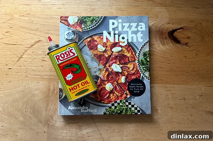 The 'Pizza Night' cookbook elegantly displayed beside a tin of Rosi's hot oil, creating an enticing pairing for any pizza enthusiast.