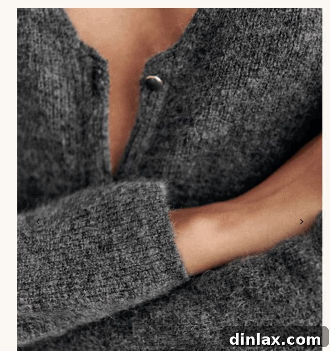 Sezane's elegant Barry cardigan in charcoal grey, draped to highlight its luxurious texture and stylish design.