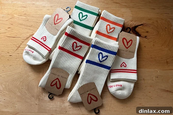 A pair of House of Shan 'Imperfect Heart' socks neatly folded on a countertop, showcasing their charming design and soft texture.