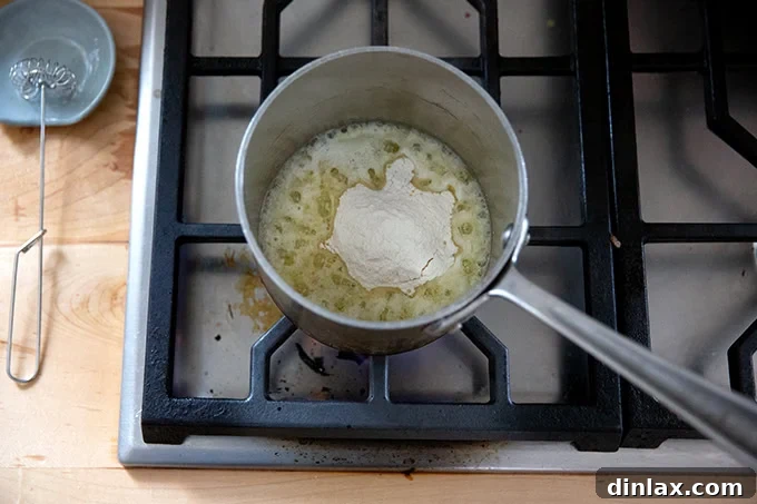 Melted butter in a small saucepan with all-purpose flour added, beginning to form a roux for the tetrazzini sauce.