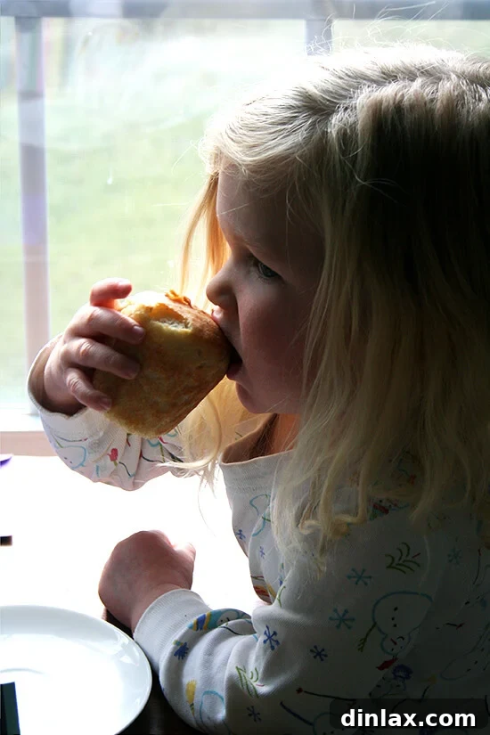 Paul Steindler's Cabbage Soup and Peasant Bread: A Hearty Duo 14 A child happily enjoying a mini loaf of peasant bread with a bowl of warm soup, a perfect comfort food pairing.