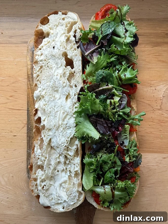A giant sandwich made on a large roll, filled with roasted red peppers and whipped ricotta.