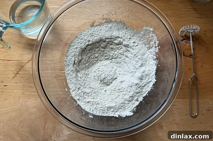 The dry ingredients to make sandwich roll dough whisked together in a large glass bowl.
