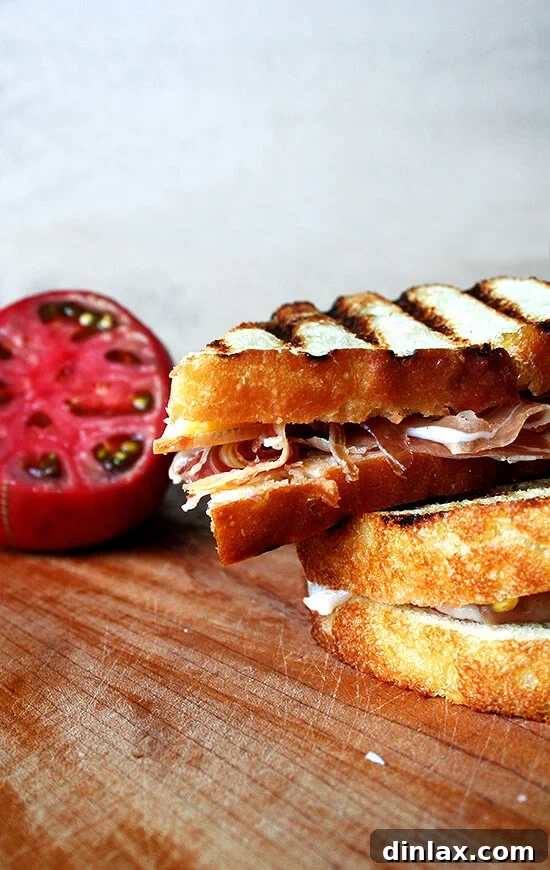 A perfectly assembled Pan con Tomate sandwich featuring toasted bread, rich Jamón Ibérico, and fresh tomato, ready to be enjoyed.